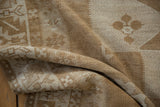 Folded vintage Oushak runner with textured pile, sand, ivory, bronze abrashes, and starburst pattern.