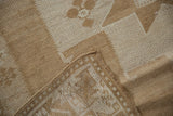 Vintage Oushak runner corner, highlighting secured edge and textured ivory-sand pattern.