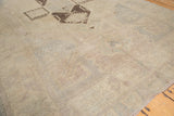 Textured pile of vintage Oushak rug with faded pastels and a charcoal brown geometric pattern.