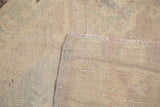 Hand-knotted pile texture, muted blanched pastels, and neatly secured fringe of Oushak rug.