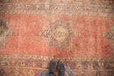 Scalloped central medallion with rectilinear design on a faded cinnabar Oushak runner.