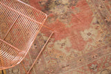 Vintage Oushak rug's hand-knotted texture with faded cinnabar red and antique ivory palette.