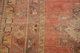 Vintage Turkish Oushak rug detail with faded cinnabar, blush, and rectilinear charcoal motifs.