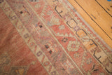 Vintage Oushak runner's even thin pile with faded cinnabar, blush, and ivory rectilinear motifs.
