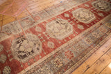 Vintage Oushak runner detail: octagonal medallion with trefoil on cherry red field and faded tones.