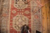 Vintage Oushak runner with faded octagonal medallion, trefoil, and splayed floral motifs on a cherry red field.