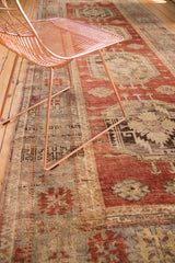 Vintage Oushak rug detail with cherry red field and splayed saffron floral designs.