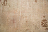 Close-up of vintage Oushak rug pile with muted bronze geometric starburst patterns.