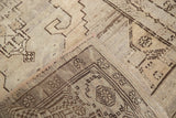 Vintage Oushak rug runner corner, showing hand-knotted pile, secured edge, and brown geometric motifs.