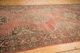 Curvilinear Rococo scrolling medallions and abrash on blush red vintage Oushak runner.