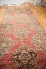 Vintage Oushak rug runner's scalloped medallion, Rococo scrolls, and abrash blush red field.