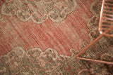 Vintage Oushak rug detail: blush to cinnabar abrash in field, light Rococo scrolling outline.