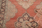 Cinnabar red vintage Sparta rug detail with scalloped charcoal and pale gold floral medallions.