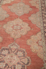 Scalloped floral medallion in pale gold and charcoal on a cinnabar red Vintage Sparta rug.