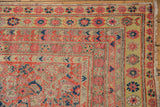 Corner detail of distressed Malayer runner, showing blush pink, orange-red Herati motifs and secure fringe.