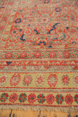 Distressed Malayer runner's intricate multiple borders in red, gold, and pink with tattered fringe.
