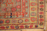 Distressed Malayer runner corner, showing even pile wear, orange-red, and pink floral motifs.