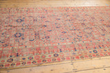 Distressed Malayer runner with faded orange-red Herati motif, worn to knot heads.