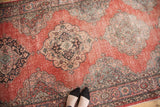 Distressed vintage Sparta runner with muted cinnabar field and repeating medallions.