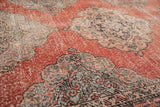 Close up of distressed cinnabar red field with oxidized green and grey medallion.