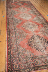 Distressed texture of the Sparta rug border, showing cinnabar, charcoal, and patina greens.