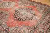 Distressed cinnabar red Sparta rug texture with worn charcoal and beige patterns.
