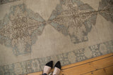 Oversized slate medallion on antique ivory field with decorative border of a vintage Oushak runner.