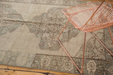 Intricate antique ivory, beige, and slate blue medallion pattern on a vintage Oushak rug section.