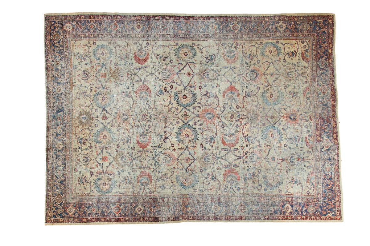 Antique Persian Mahal carpet with distressed allover splayed floral design in ivory, blues, and terra cotta.