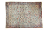 Antique Persian Mahal carpet with distressed allover splayed floral design in ivory, blues, and terra cotta.