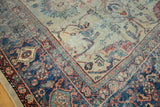 Decorative corner of an antique Mahal rug, blanched saffron field and navy floral border.