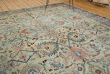 Distressed antique Mahal carpet with splayed floral patterns in blanched saffron, sky blue, and blush.