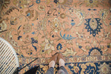 Vintage Tabriz carpet with peach field, scrolling vines, lotus design, and navy border.