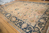 Vintage Tabriz rug corner, peach apricot field, navy border, and scrolling floral palmettes.