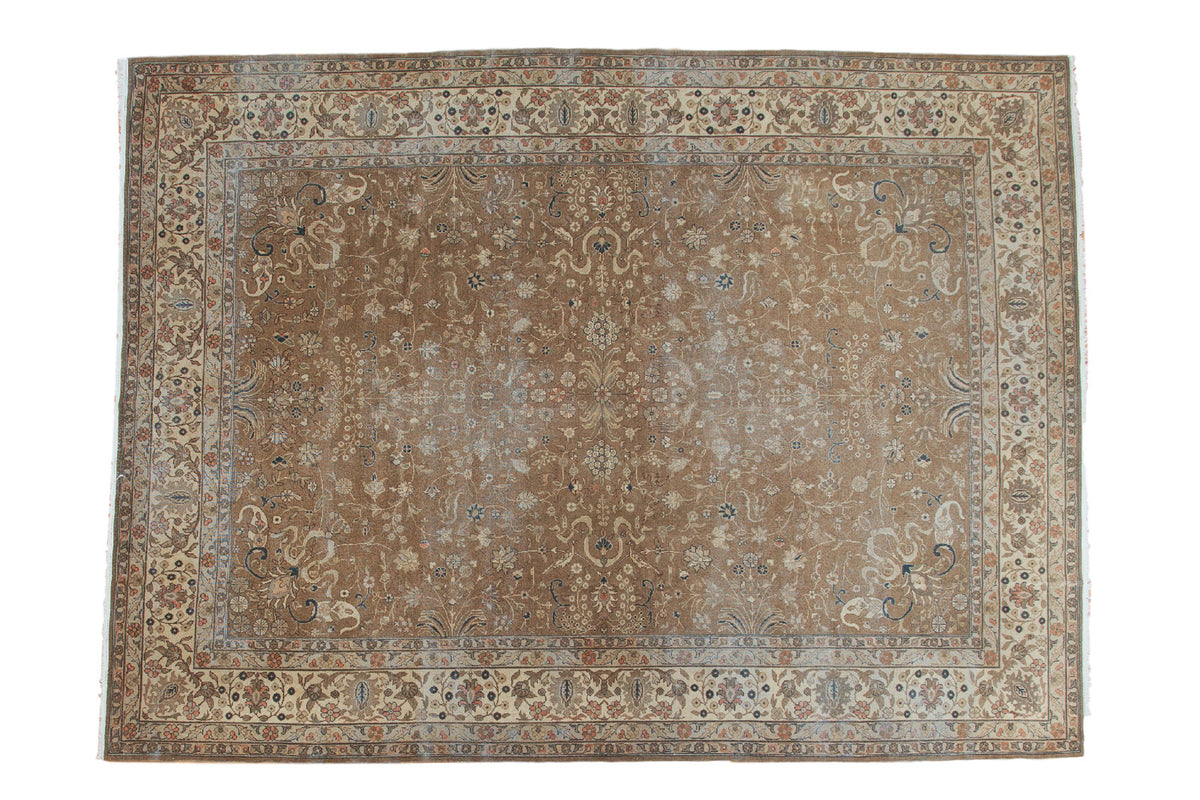 Distressed Romanian carpet with faded bronze allover floral field and antique ivory border.