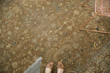 Distressed Romanian carpet texture, faded bronze field with delicate floral vinery in blush, navy, ivory.