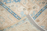 Distressed Sivas rug corner, aqua floral pattern, light field, woven back, secured edge.