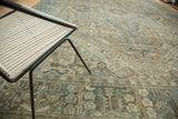 Textured distressed Karaja rug showing faded blue and sand curvilinear motifs.