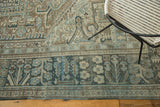 Distressed Karaja carpet border and field with sand, ivory, and blanched blue motifs.
