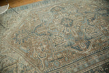 Textured distressed Karaja rug showing curvilinear Herati-style motifs in blanched blues and sand.