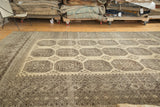 Triple gul motifs and intricate rectilinear borders with abrashes on a distressed Afghan carpet.