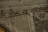 Distressed texture with abrashes, showing rectilinear motifs, secured side binding, and fringe.