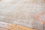 Distressed Sivas carpet showing mixed texture of flat woven and short pile, beige and ivory.