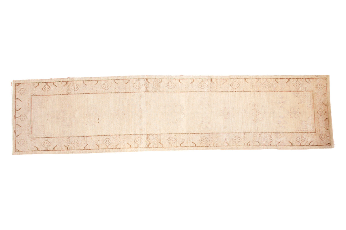 Antique distressed Khotan runner, ivory and beige with a subtle faded floral pattern, 3x12 feet.