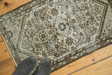 Distressed antique Malayer rug showing allover Herati pattern in muted gray and ivory.