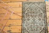 Distressed antique Malayer rug's Herati motif, showing ivory, charcoal, and powder blue tones.