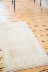 Pale sand vintage Oushak rug mat with subtle ivory and sea foam octagonal medallion.