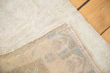 Hand-knotted foundation and secured edge of vintage Oushak rug, showing pale pile and pattern.