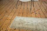 Hand knotted vintage Oushak mat in pale wooded tones with asymmetric medallion.
