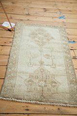 Vintage Turkish Oushak rug corner showing secured side, faint geometric border, and wooded tones.